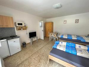 a hotel room with two beds and a kitchen and a kitchen at Ubytovanie Klára in Veľký Meder +4 photos