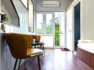 a room with chairs and a table and a bed at Homestay Chân Mây in Tam Ðảo