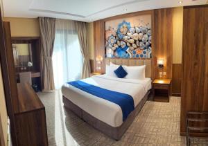 a bedroom with a large bed with a painting on the wall at Lanai Hotel فندق لاناي in Jeddah +57 photos