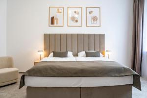 a bedroom with a large bed and a chair at Petit Dependance in Bratislava