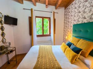 a bedroom with a bed with a green headboard and a window at El Molino de la Ropería in Serrilla