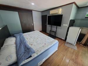a bedroom with a bed and a flat screen tv at Baan Mo in Ban Kata