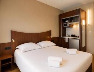 a bedroom with a large white bed with two towels on it at Logis Hotel Center in Brest +49 photos