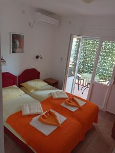 a bedroom with two beds with towels on them at Apartmani CECA 012 Sutomore in Sutomore