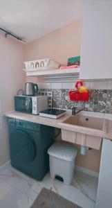 a kitchen with a sink and a washing machine at Casita con mirador in Málaga