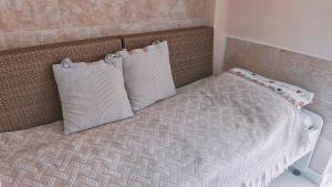 a bed with two pillows on top of it at Casita con mirador in Málaga