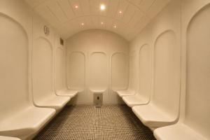 a row of urinals in a bathroom with a tile floor at Logis Hotel Center in Brest