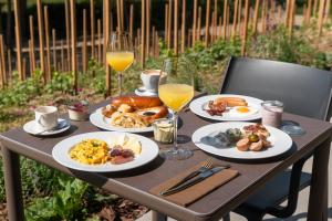 a table with plates of food and two glasses of orange juice at ARTEVINI Resort & Winery in Velké Pavlovice