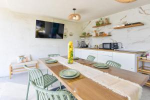 a kitchen and dining room with a wooden table and chairs at Vila Manuela Techirghiol in Techirghiol