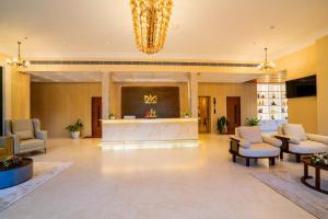 a lobby with chairs and a reception desk and a chandelier at HOTEL MARIAPARK KALLooRKKAD in Vāzhākulam