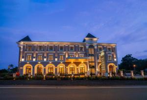 a large building with lights on it at night at HOTEL MARIAPARK KALLooRKKAD in Vāzhākulam