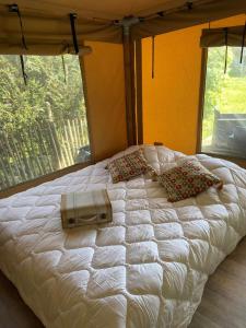 a large white bed in a room with a window at Lodge La Vie Douce in Vigeois
