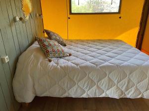 a bedroom with a white bed with a yellow wall at Lodge La Vie Douce in Vigeois +5 photos