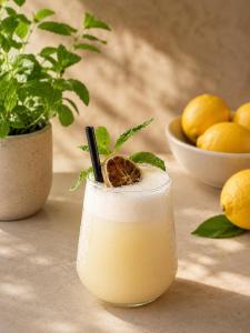 a drink sitting on a table next to a bowl of lemons at Cleo Hotel in Alanya