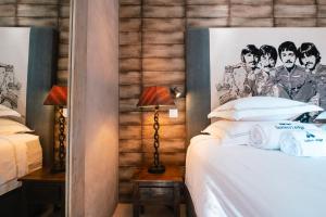 a bedroom with a bed with a poster of the beatles at Surfers Lodge Peniche in Peniche