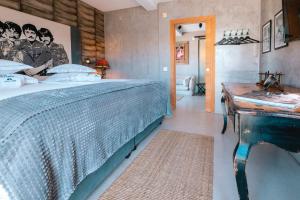 a bedroom with a large bed and a table at Surfers Lodge Peniche in Peniche