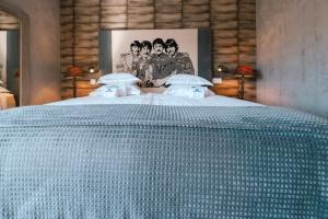 a large bed with a blue comforter in a bedroom at Surfers Lodge Peniche in Peniche