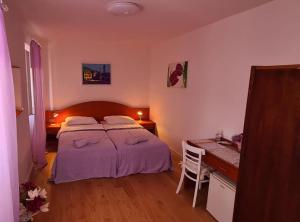 a bedroom with a bed and a desk with a desk at Rooms Milena in Lopud