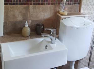 a white sink in a bathroom with a toilet at Rooms Milena in Lopud