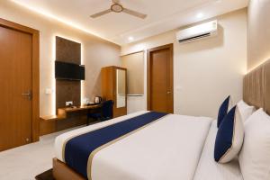 a hotel room with a bed and a desk at Hotel Shree Near Prem Mandir in Chhatikara