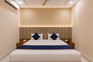 a bedroom with a large bed with blue pillows at Hotel Shree Near Prem Mandir in Chhatikara
