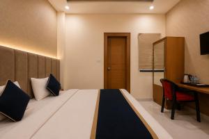 a hotel room with a bed and a desk and a table at Hotel Shree Near Prem Mandir in Chhatikara +17 photos