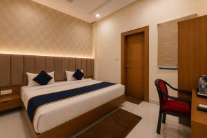 a bedroom with a bed and a desk and a chair at Hotel Shree Near Prem Mandir in Chhatikara