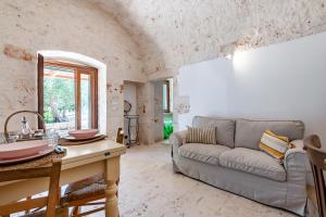 a living room with a couch and a table at Lamia Terra 3BR, Terrace & BBQ - Happy Rentals in Castellana Grotte