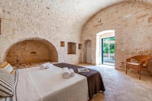 a bedroom with a bed with towels on it at Lamia Terra 3BR, Terrace & BBQ - Happy Rentals in Castellana Grotte +26 photos