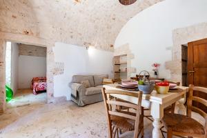a kitchen and living room with a table and chairs at Lamia Terra 3BR, Terrace & BBQ - Happy Rentals in Castellana Grotte