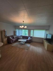 a living room with a couch and a table at Revontulet ZH Tulimetsän Kylä in Pieksämäki