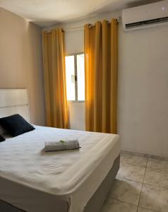 a bedroom with a large bed with yellow curtains at Hotel Lisboa II in São José dos Campos