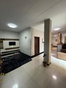 a large living room with a couch and a tv at Hotel Lisboa II in São José dos Campos