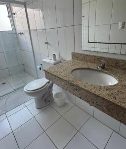 a bathroom with a toilet and a sink and a shower at Hotel Lisboa II in São José dos Campos