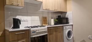 a kitchen with a stove and a washing machine at Breakpoint Loft - City Center in Łobez