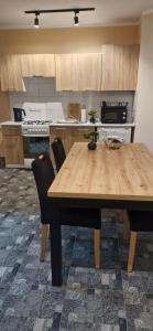 a kitchen with a wooden table and chairs at Breakpoint Loft - City Center in Łobez