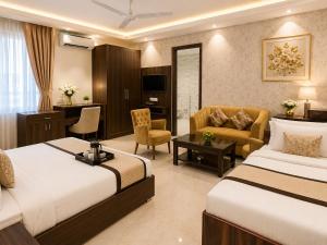 a hotel room with two beds and a living room at Akshay Hotel in Gurgaon