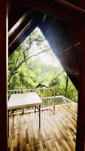 a bench sitting on a wooden deck with a view at Green Forest Cabanas - Ella in Ella