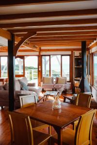 a living room with a wooden table and chairs at Surf Lodge South Africa in Jeffreys Bay +56 photos