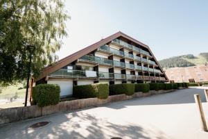an apartment building with a gambrel roof at Le Nid Cozy - Appart avec Piscine, Terrain de Tenis et Balcon in Métabief