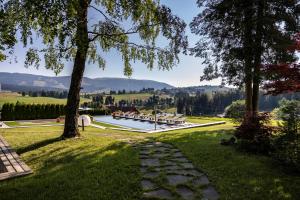 Ein Garten mit Pool und Bergen im Hintergrund in der Unterkunft Linta Hotel Wellness & Spa in Asiago