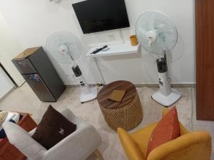 a living room with two chairs and a fan at Cosy Masta 1 in Pointe-Noire