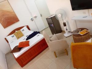 a bedroom with a bed with a chair and a desk at Cosy Masta 1 in Pointe-Noire