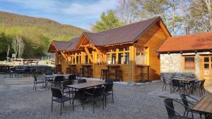 a log cabin with tables and chairs in front of it at Velebit House in Baške Oštarije