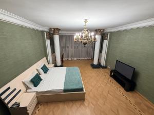 a large bedroom with a bed and a chandelier at Hotel All Time in Tbilisi City