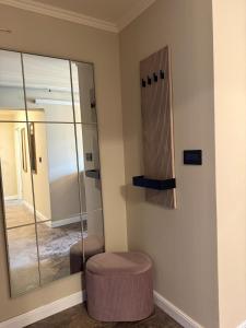 a mirror in a room with a stool and a chair at GZP Residence Lugoj 5 in Lugoj