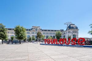 a large building with a large sign that reads volunteer at Hôtel Icare in Toulouse