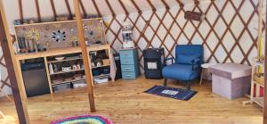 a room with a blue chair in a yurt at Martinická jurta in Martinice u Dolních Kralovic
