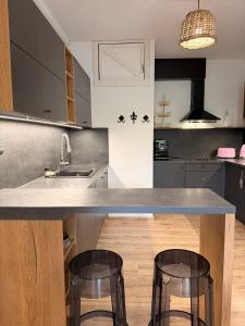 a kitchen with a counter and two bar stools at MM Rooms in Bled