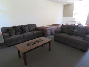 a living room with two couches and a coffee table at Emerald Gardens Motel & Apartments in Emerald